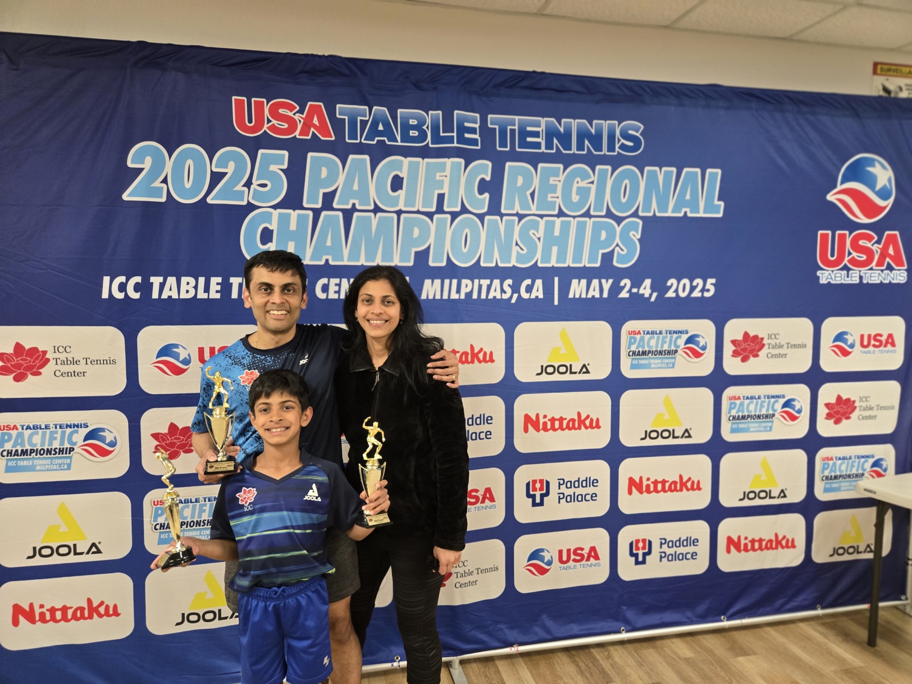 Srini and Disha with a young athlete at the 2025 Pacific Regional Championships